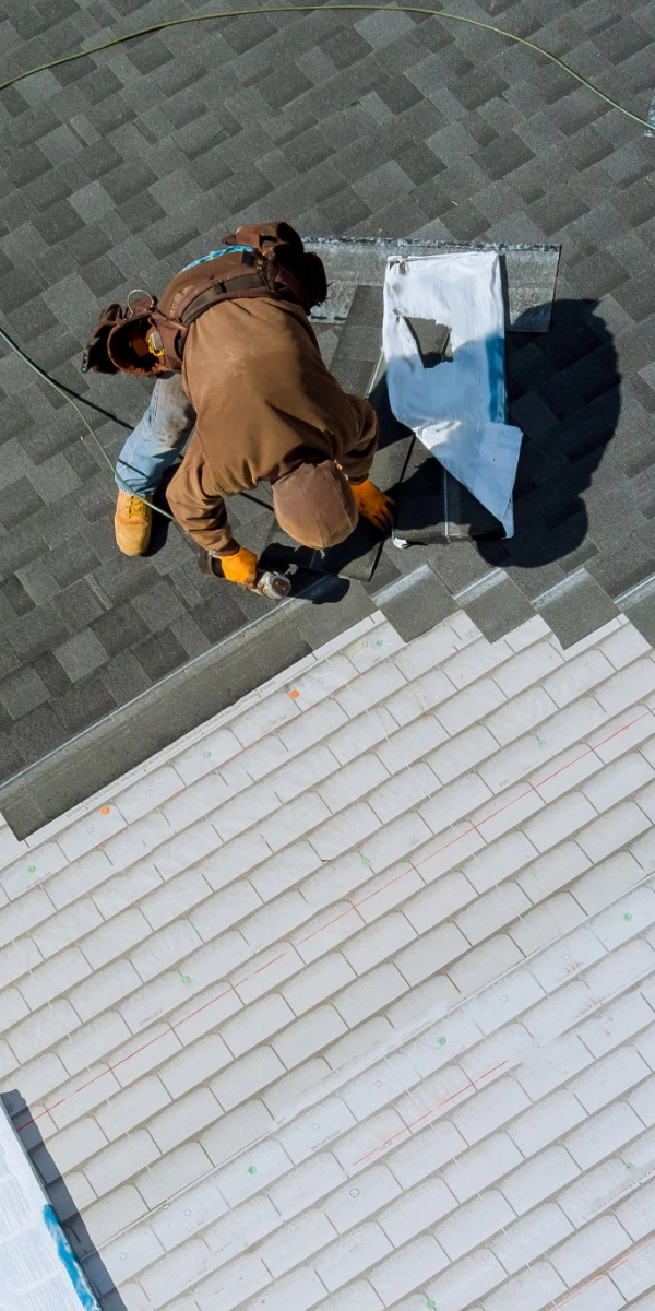 An employee from a roofing company in Inner Richmond installs new shingles on a home.
