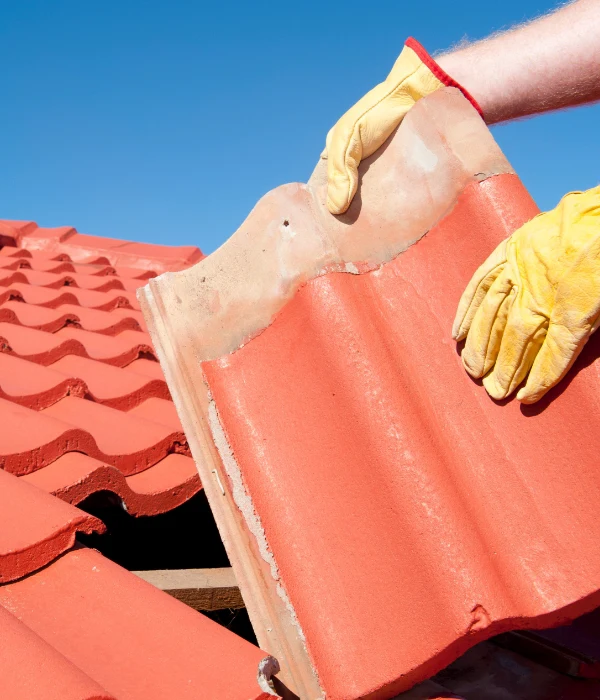 A roofer replacing tiles on a California home.